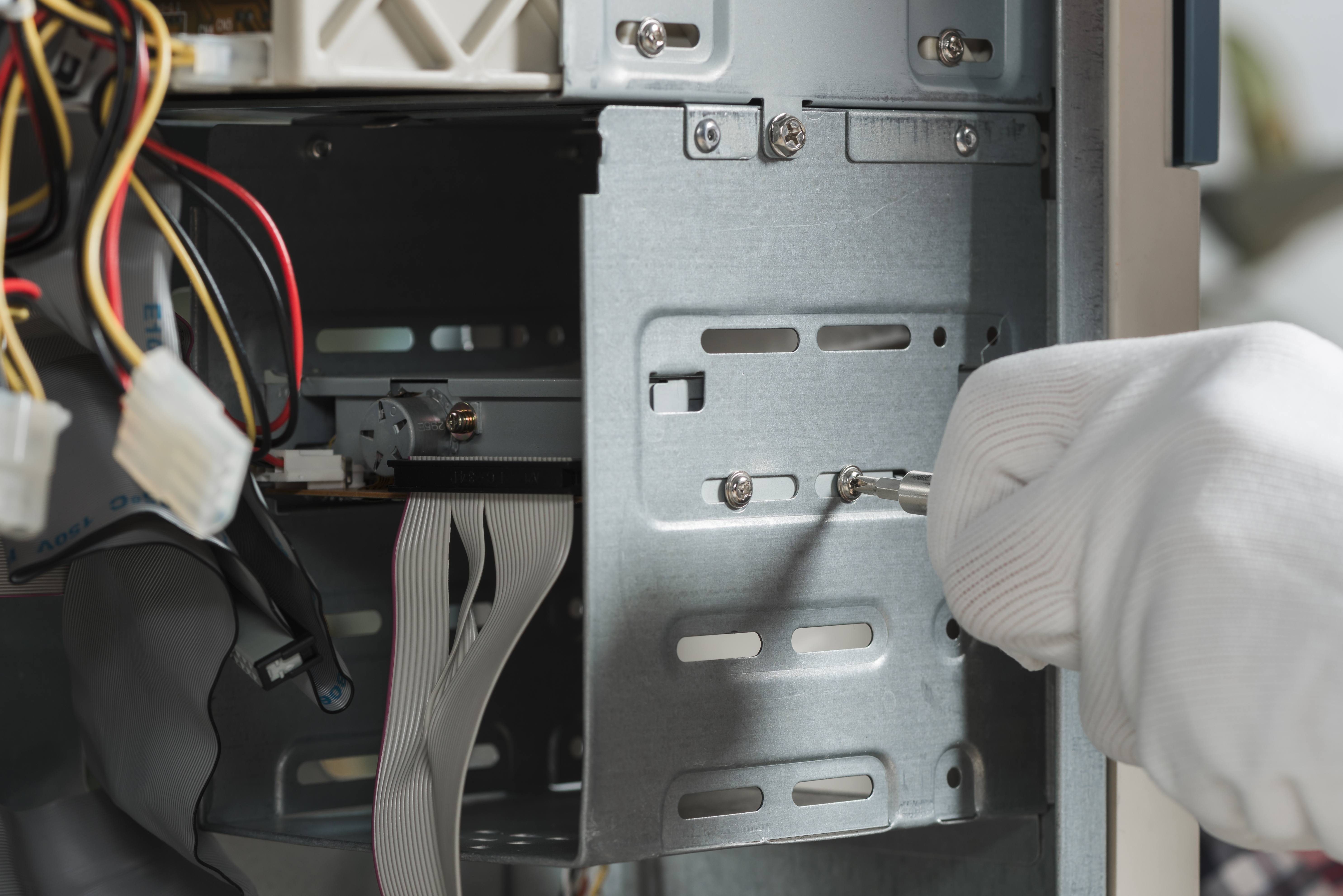 close-up-male-technician-hand-wearing-gloves-fixing-screw-computer-slot